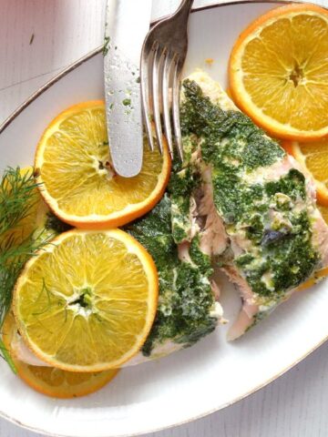 salmon with white wine sauce served with orange slices