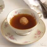 roasted vegetable broth with one hazelnut dumplling in a vintage tea cup.