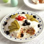 Romanian salad de boeuf decorated with mayonnaise and olives