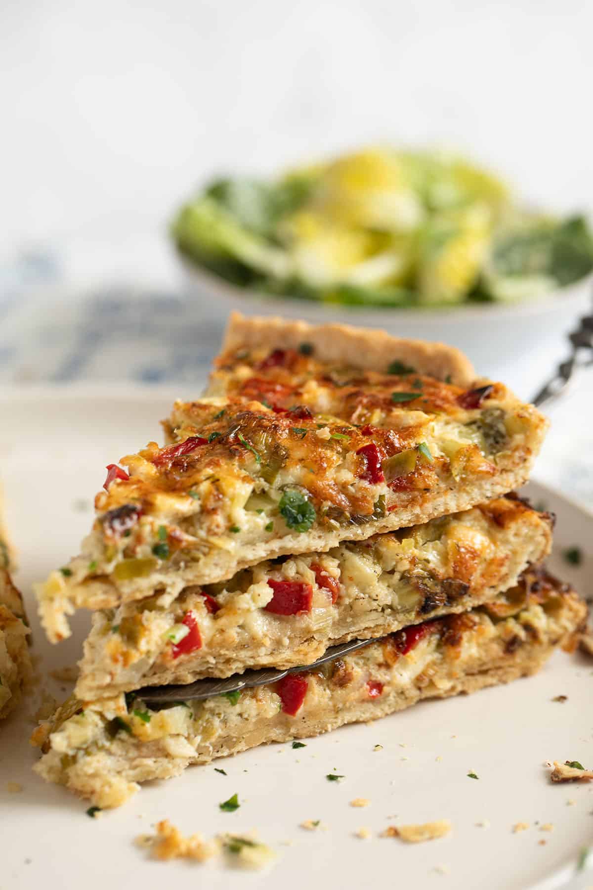three slices of green onion quiche stapled on a plate.