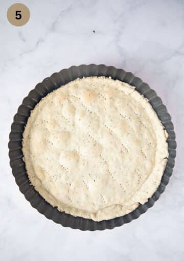 pre-baked dough fpr quich in a baking dish.