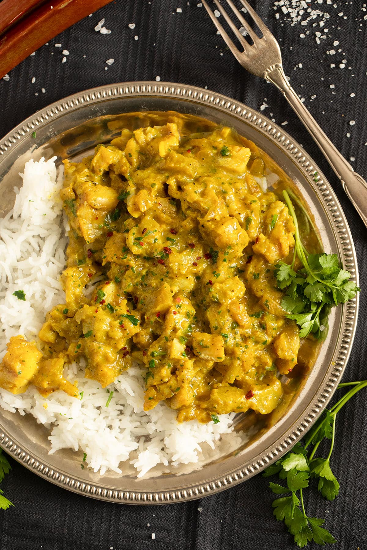 fish and rhubarb curry served with rice on a vintage plate.
