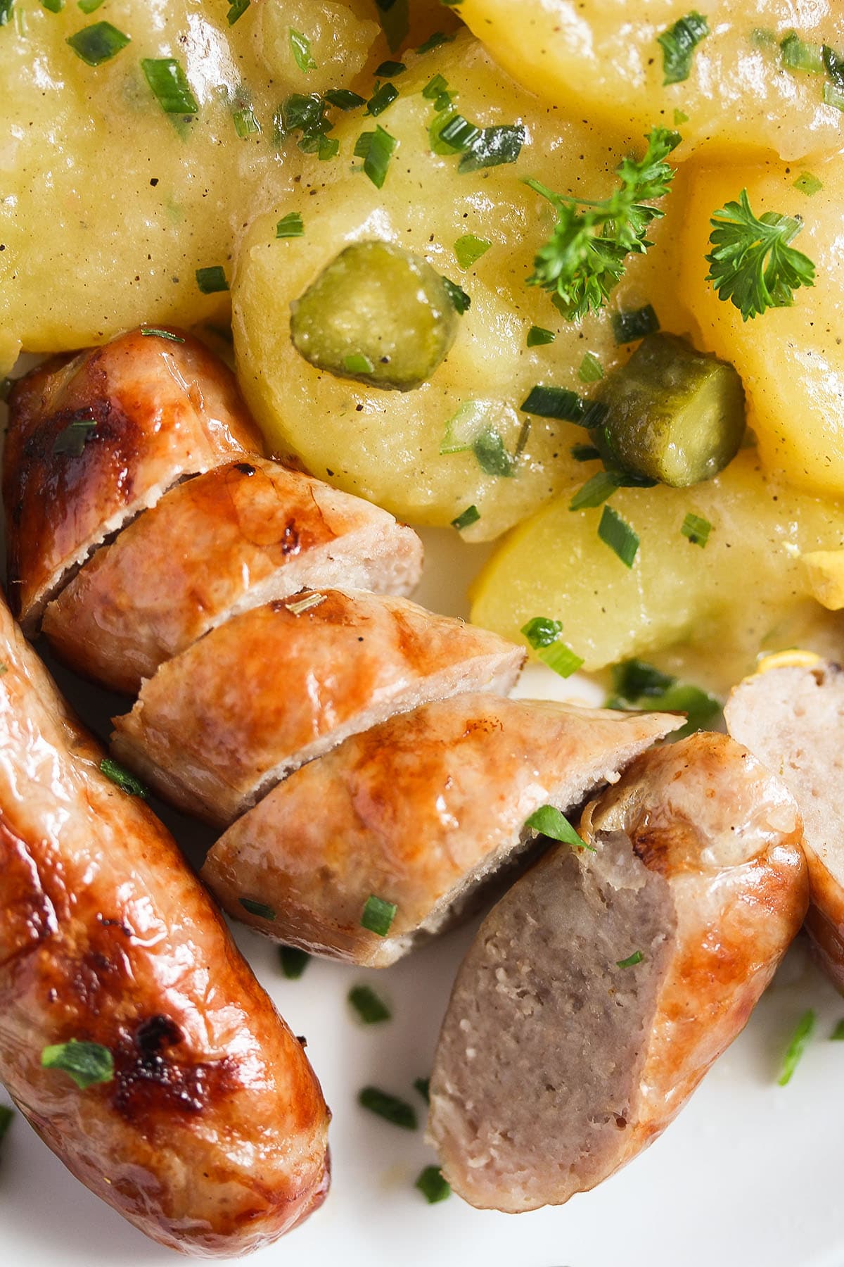 close up sliced sausages and potato salad german style.