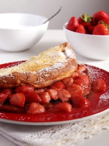 close up strawberry filled thick large pancake on a plate