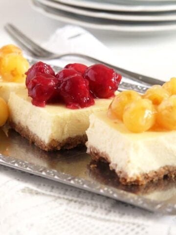 cake slices topped with red and yellow cherries
