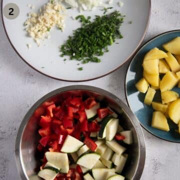 three plates with chopped cooked potatoes, chopped zucchini and peppers, and chopped garlic, onion and herbs.