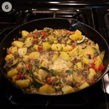 adding cream to zucchini, beef and potato skillet.