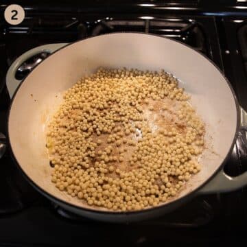 toasting pearl couscous in a large dutch oven.