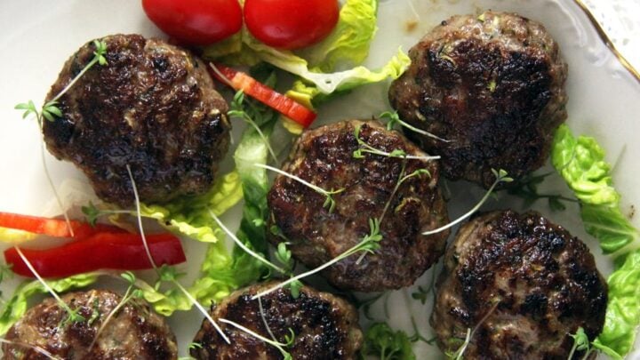 meatballs with zucchini and beef served with cherry tomatoes and salad leaves.