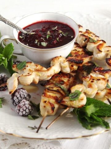 blackberry chicken on a plate decorated with fresh mint