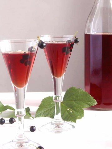homemade creme de cassis recipe in two small glasses and in a bottle