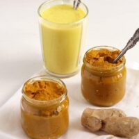 jars with turmeric paste for golden milk and a cup of golden milk