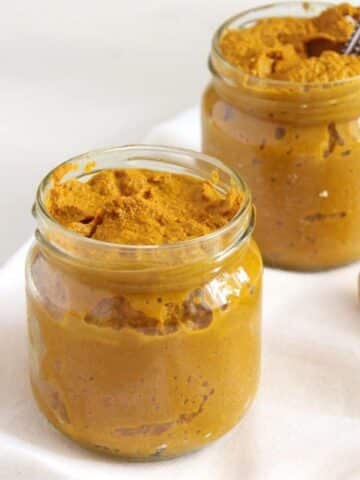 two small jars full of turmeric paste for making golden milk.