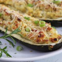 vegetarian stuffed zucchini being served on a white plate