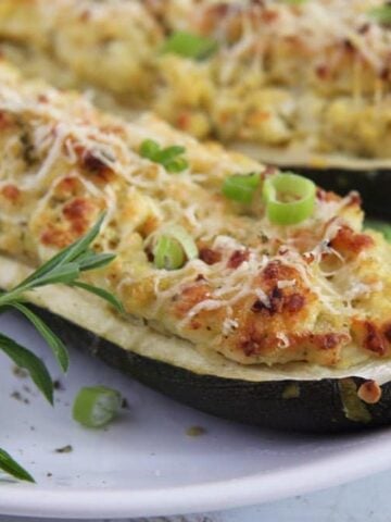 vegetarian stuffed zucchini being served on a white plate
