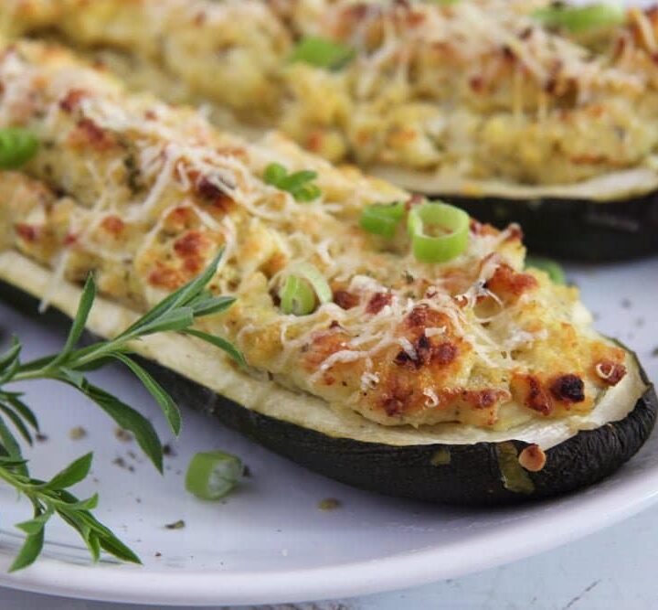 vegetarian stuffed zucchini being served on a white plate
