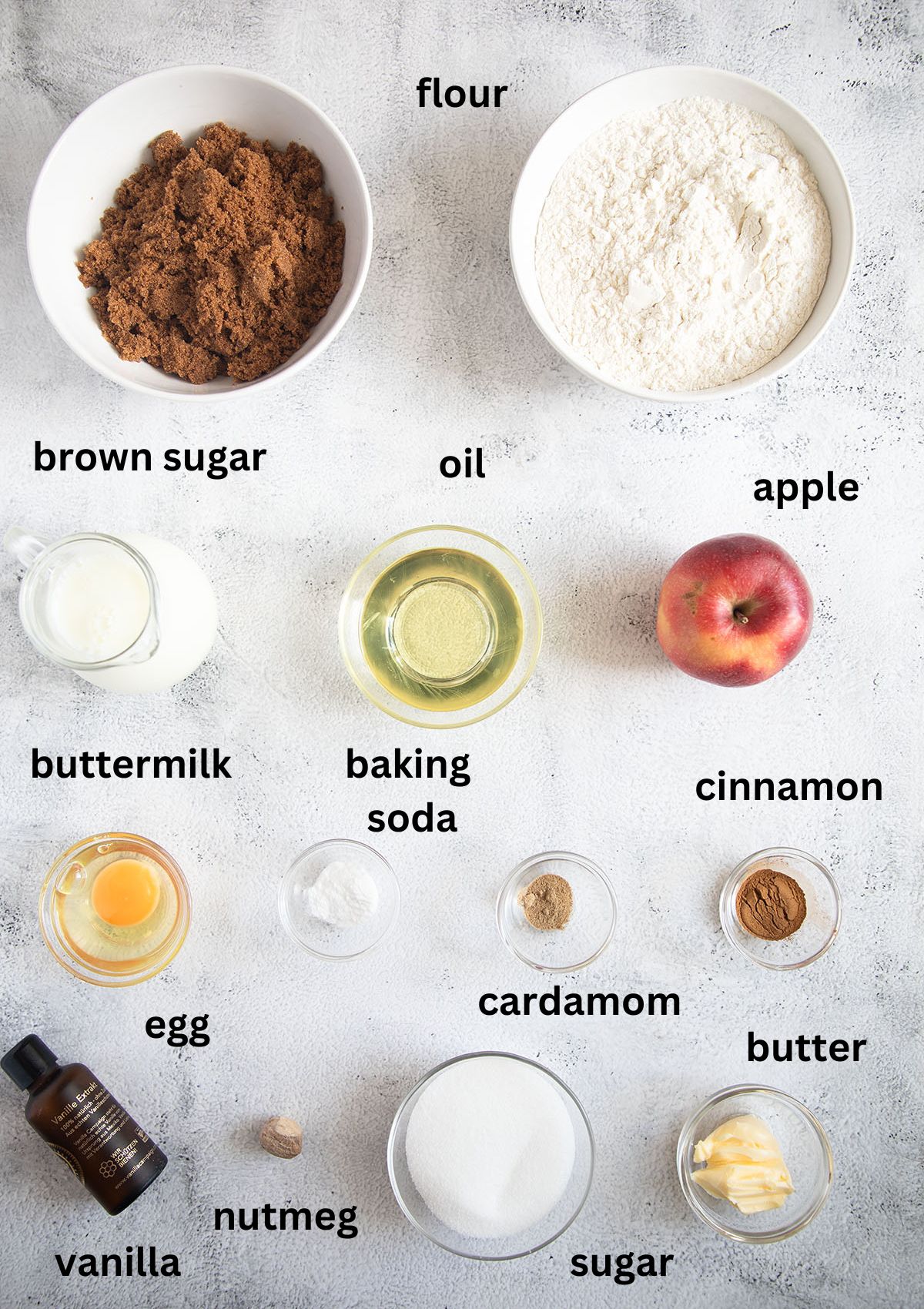 listed ingredients for making cake with brown sugar, cinnamon and apples on the table.