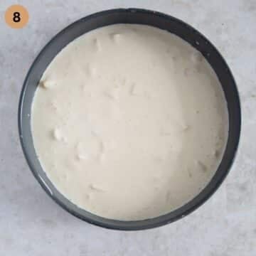 adding the cheesecake filling on the baked crust in a springform.