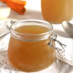 homemade broth in a large jar and in a bottle.