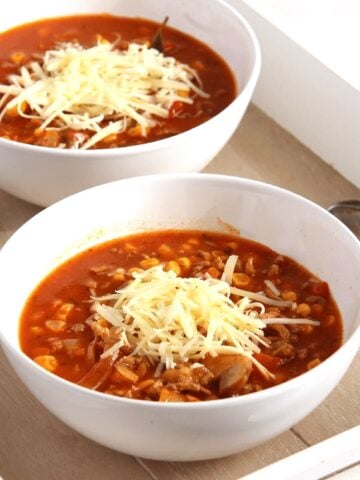 cheesy pizza soup with beef and cheese on top