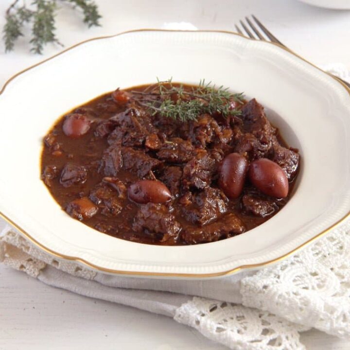 beef stew with red wine and olive on a white plate
