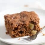 a square piece of brown sugar cinnamon cake with a fork on a plate.