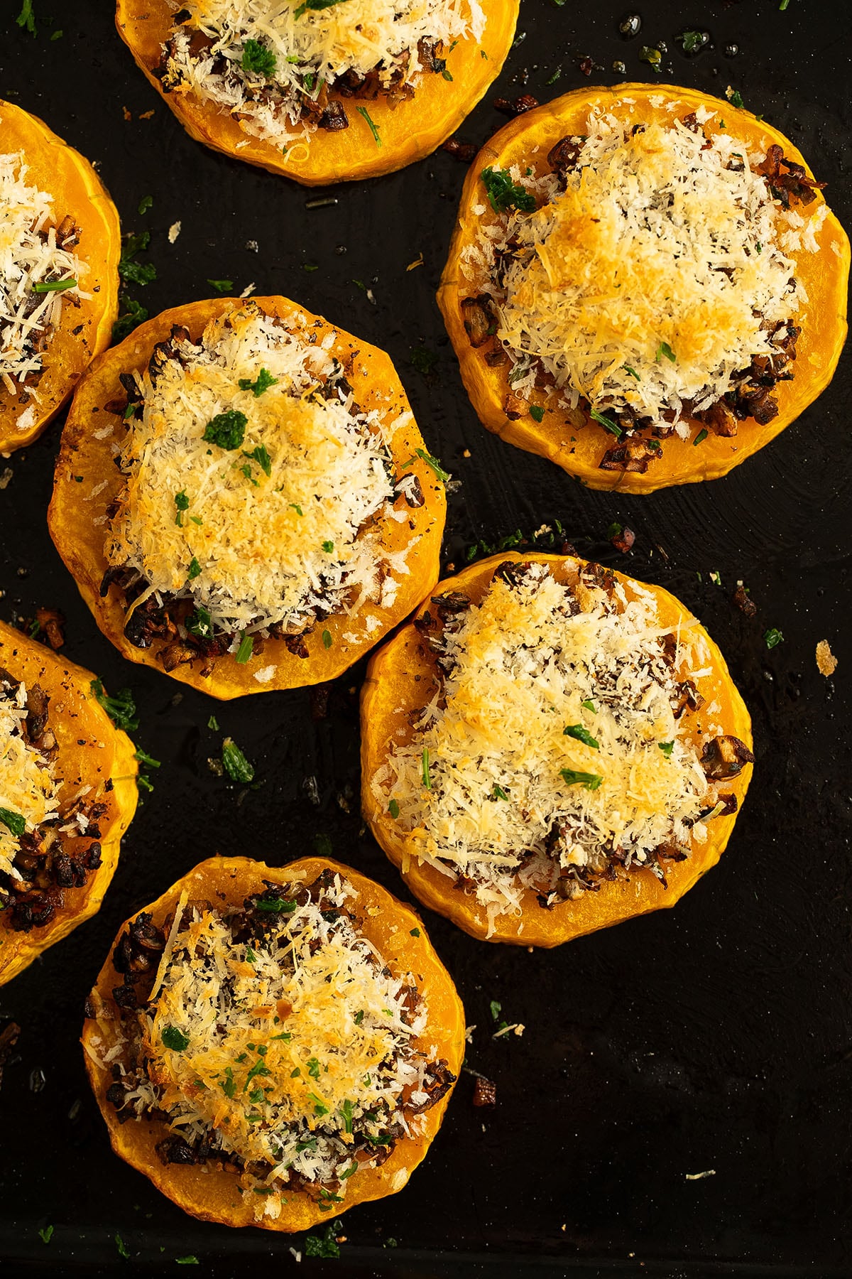 many roasted butternut slices topped with mushrooms, parmesan and panko breadcrumbs.