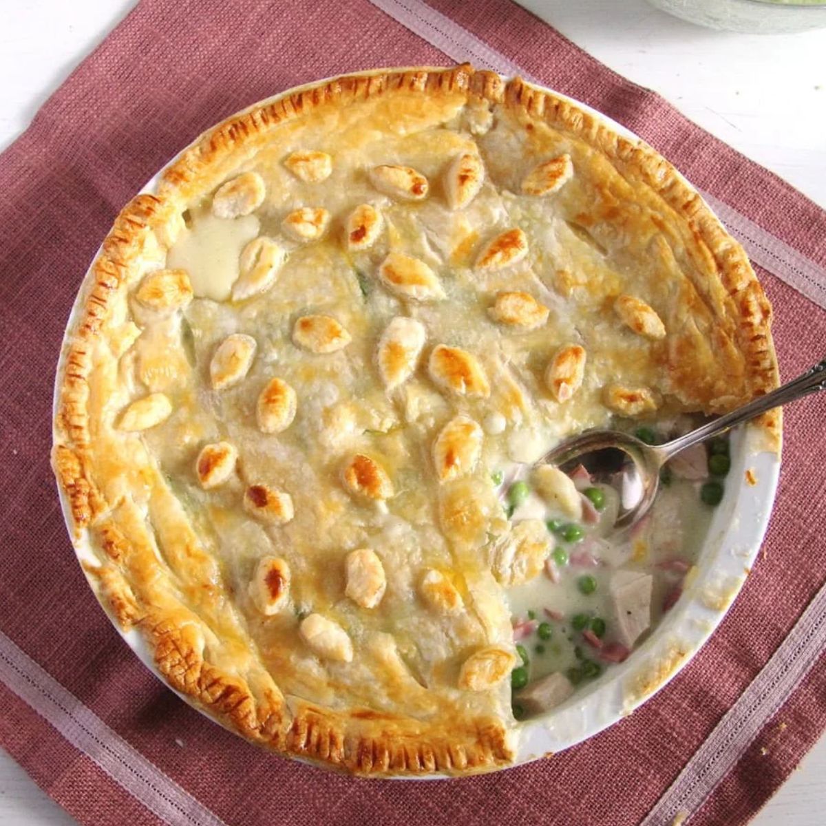 chicken and ham pie with a piece of crust missing and showing the filling,