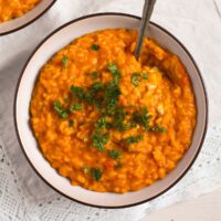 pumpkin gorgonzola risotto in a bowl with parsley on top.