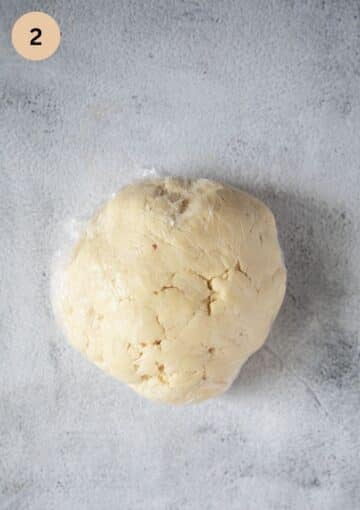 pie dough for pasties wrapped in plastic wrap on the table.