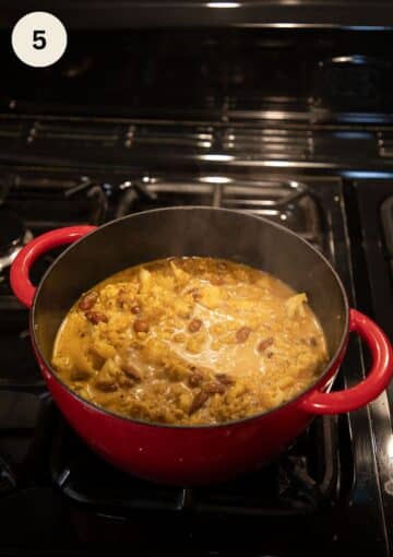 simmering cauliflower soup with almonds in a dutch oven.