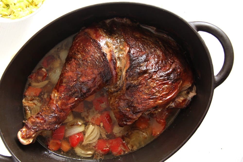 slow cooked turkey leg in a cast iron pot