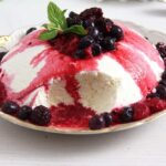 incredibly creamy yogurt cream dessert topped with berry sauce