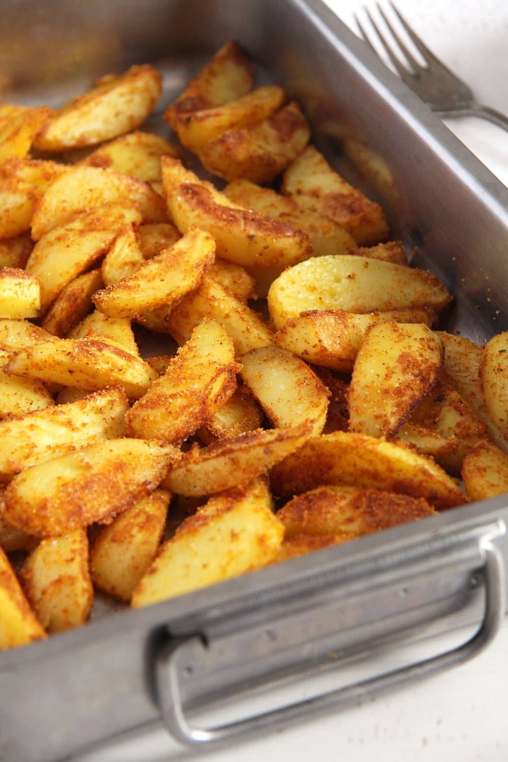 tin full of polenta roasted potatoes close up.