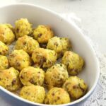cheesy balls with cornmeal and sausages in a blue baking dish