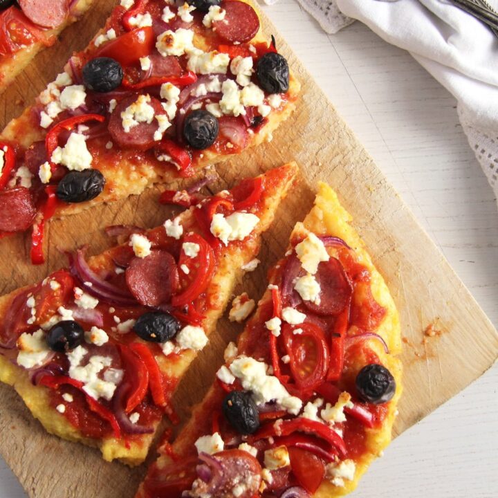 slices of leftover polenta topped with sausages and olives