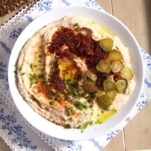 romanian fasole batuta or white bean dip with gherkins and onions in a bowl.