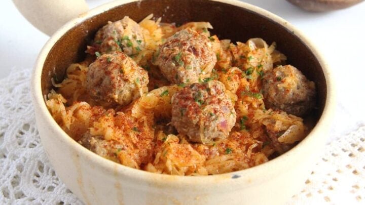 sauerkraut meatballs in a small dish on a white cloth
