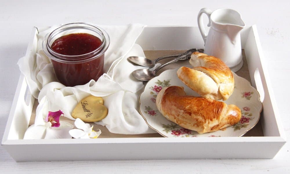 breakfast tray with croissants, jam, chocolate and milk