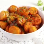 potatoes with tomato sauce in a white bowl