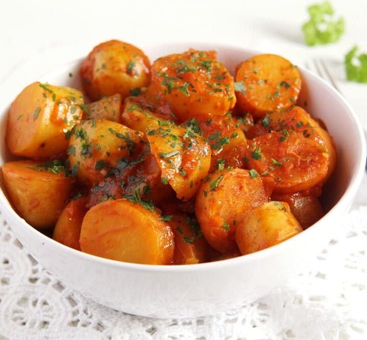 potatoes with tomato sauce in a white bowl