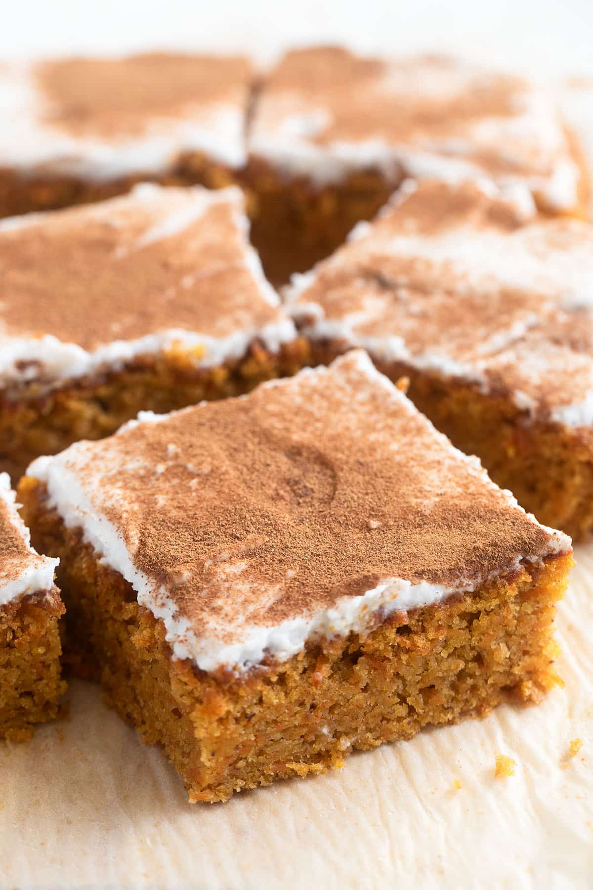 spelt flour carrot cake bars with coconut frosting and cinnamon.
