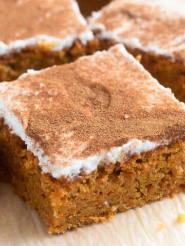 spelt flour carrot cake pieces frosted with coconut cream and cinnamon.