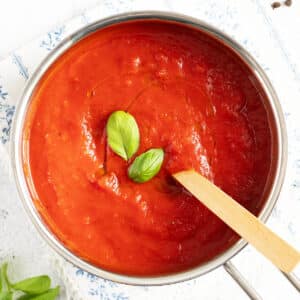 spicy marinara sauce in a small pot with a wooden spoon in it.