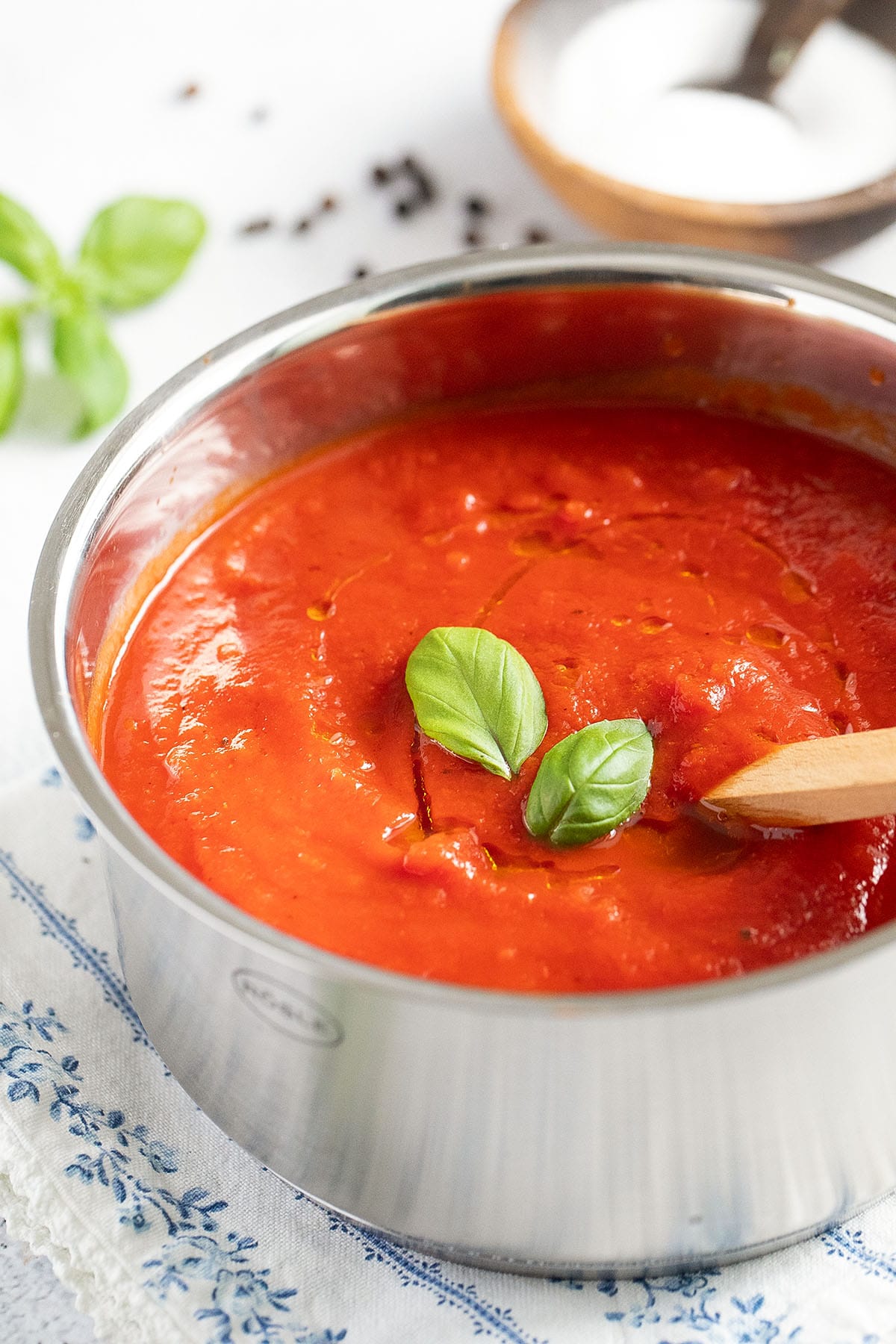 spicy marinara sauce garnished with basil leaves in a pot.