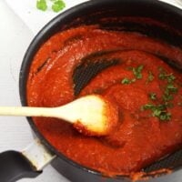 spicy marinara sauce stirred with a wooden spoon