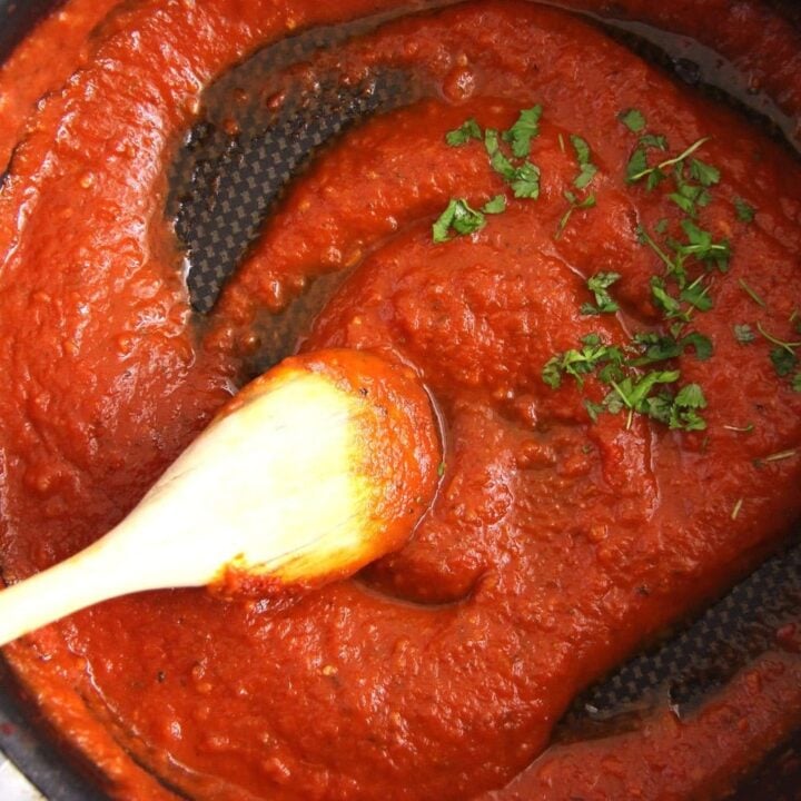 thick and spicy tomato sauce marinara stirred with a wooden spoon