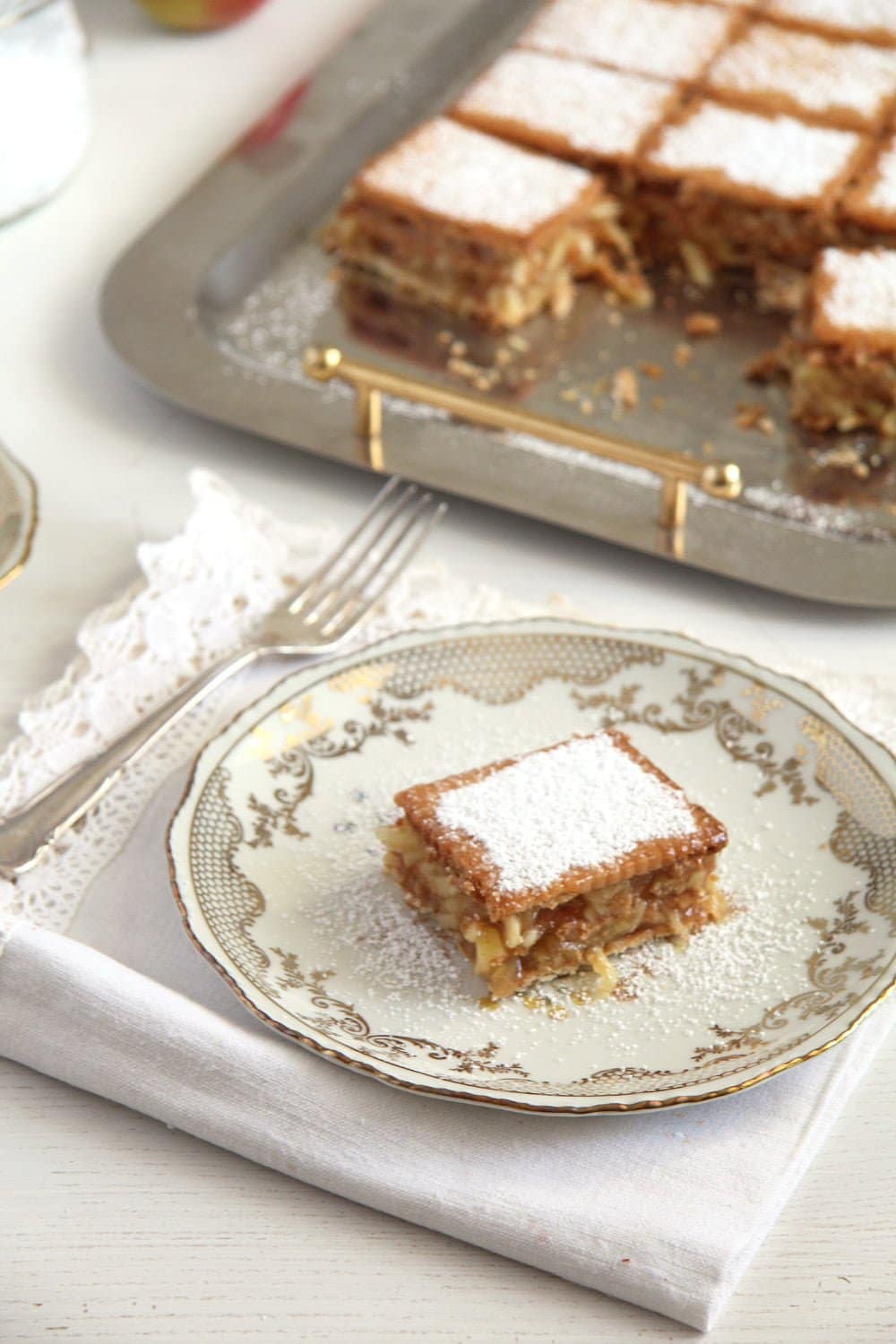 biscuit apple cake sprinkled with icing sugar on vintage dishes