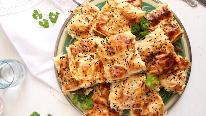 spinach borek sliced into pieces and sprinkled with nigella seeds