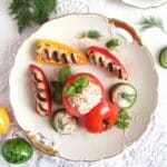 cream cheese stuffed mini peppers, tomatoes and cucumbers on a vintage plate.